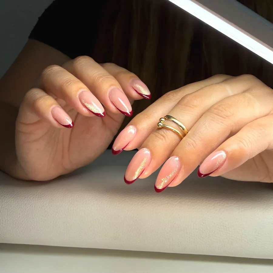 Burgundy French tip almond nails with gold shimmer by Legacy Nail Studio, Austin TX