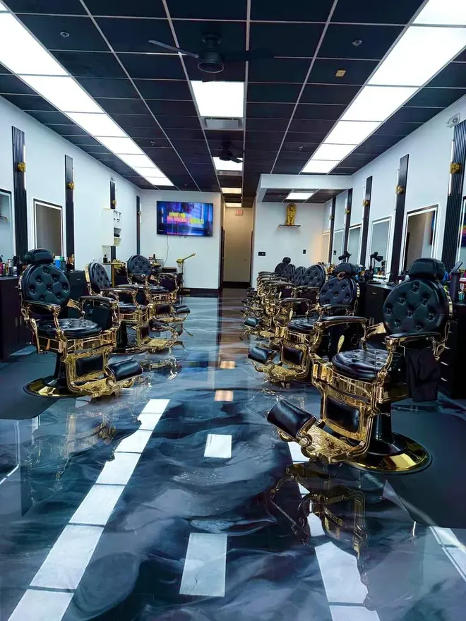 Gold barber chairs lining both walls at Legacy Barbershop