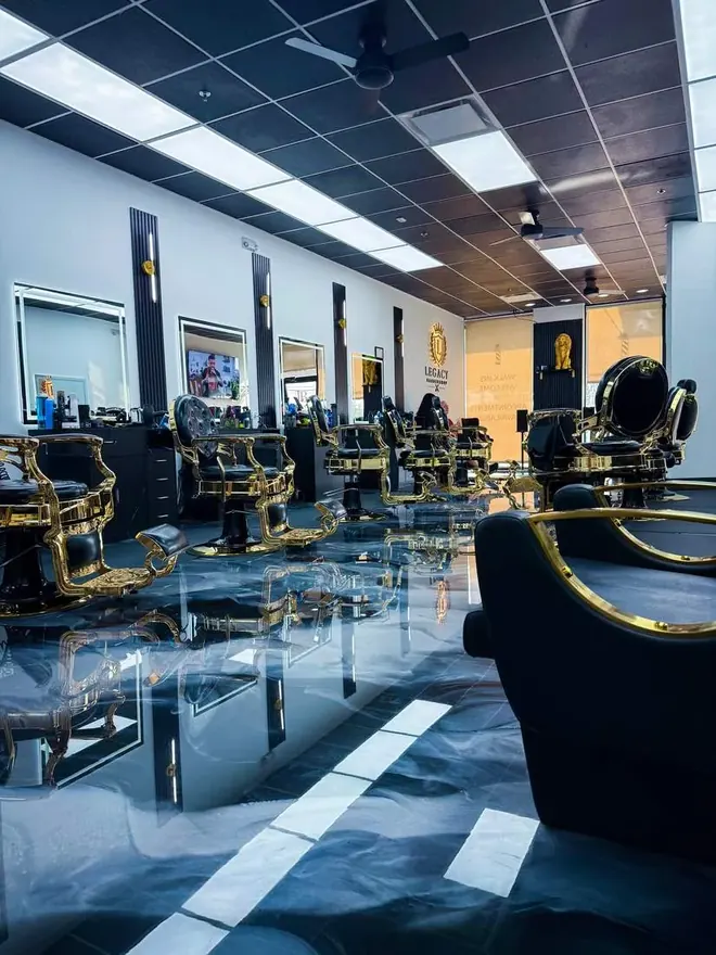 Legacy Barbershop lobby with lit wall crest